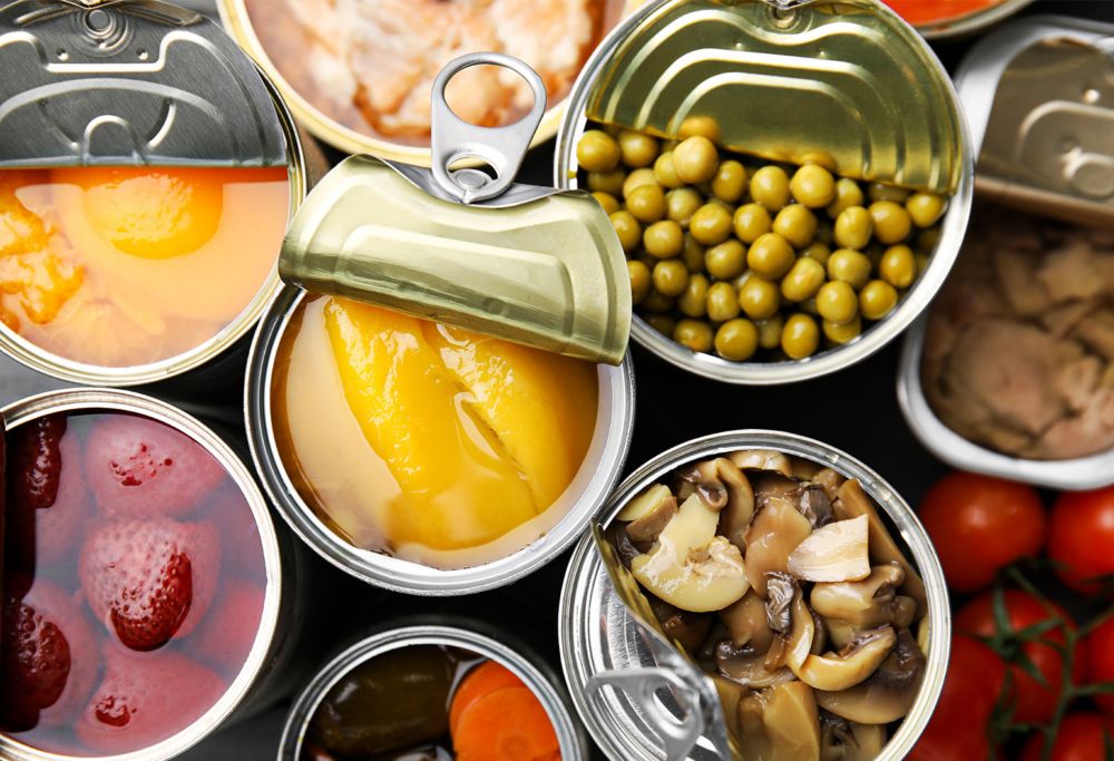 Top view of open tin cans with different food products. 
