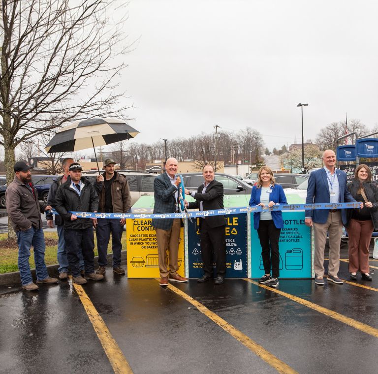 Eastman and Food City leaders cut the ribbon in front of bins for the Shop, Recycle, Repeat program. 