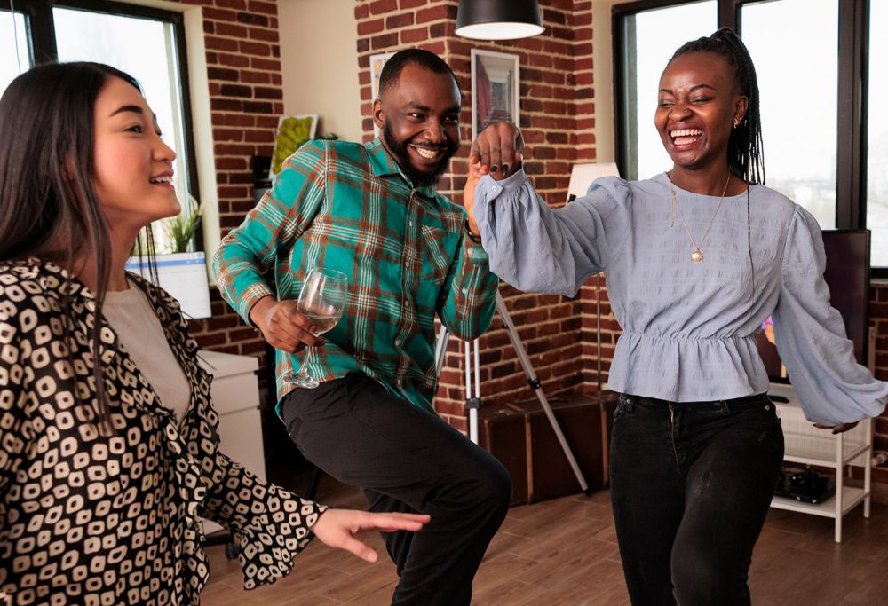 An instructor teaching a smiling couple how to dance. 