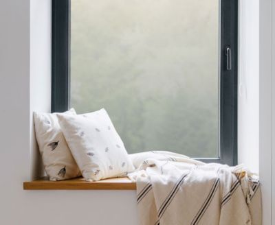 Cozy, private window nook showing the installed Frosted Glass film behind throw pillows.