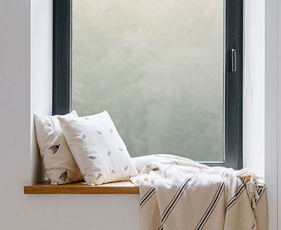 Cozy, private window nook showing the installed Frosted Glass film behind throw pillows.