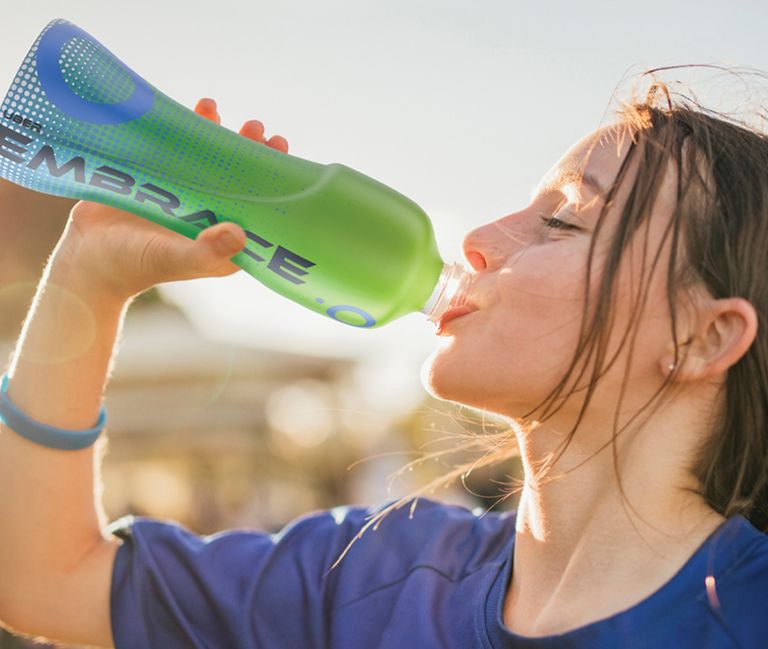 A child drinks out of a water bottle. 