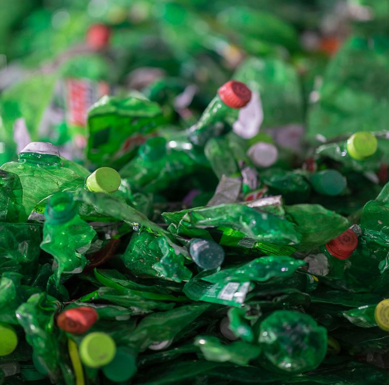 Green plastic bottles pile closeup. 