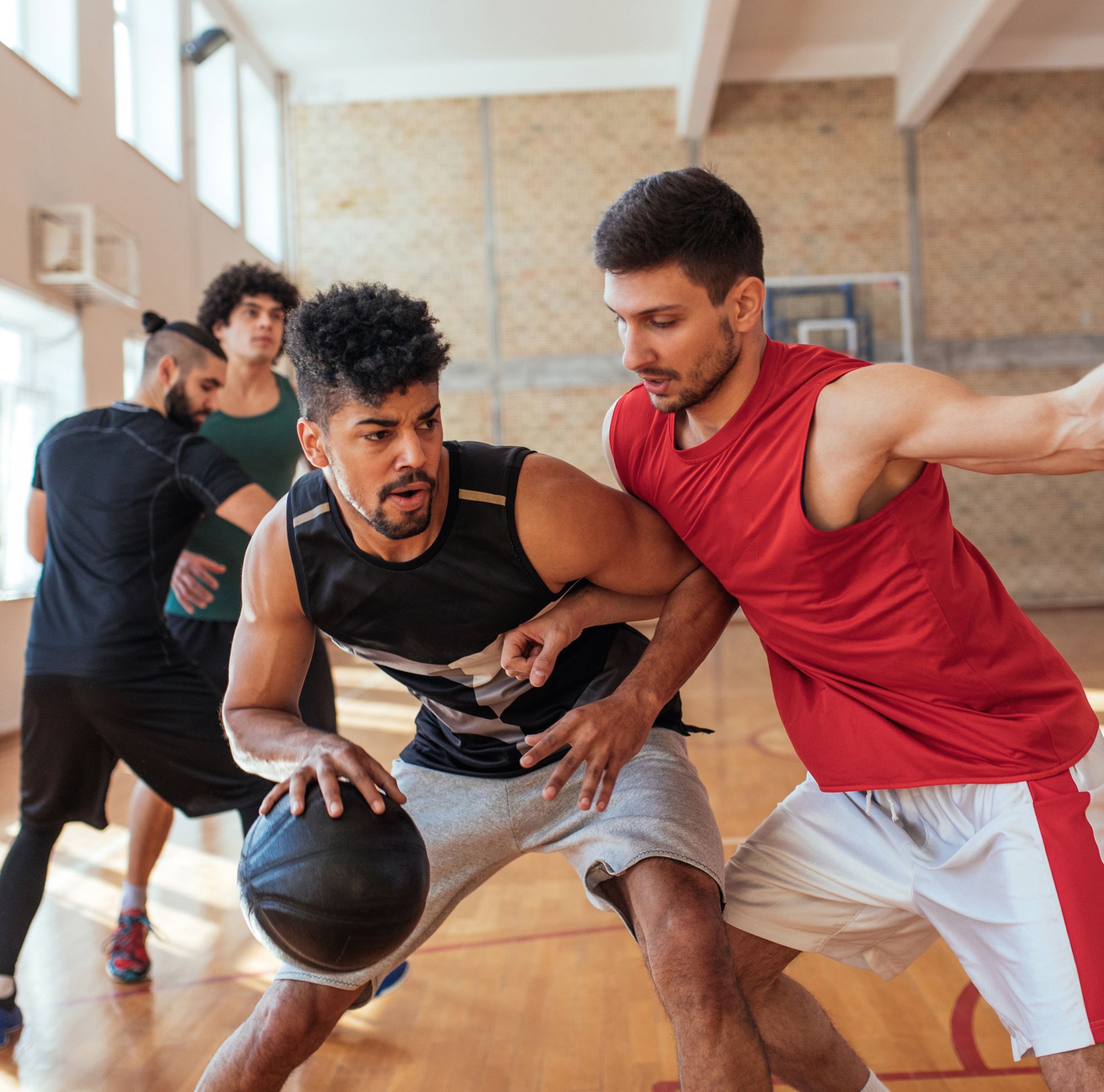 Group playing basketball at the gym 