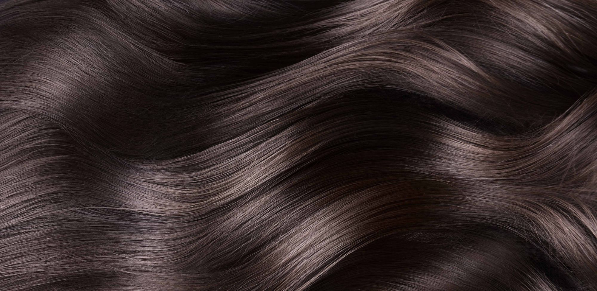 Close-up of shiny, dark and wavy hair.   