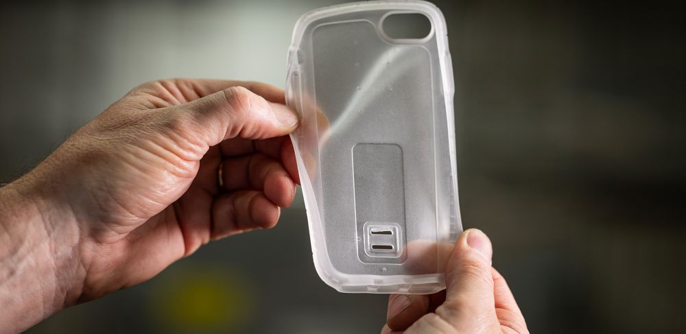 Hands hold an opaque overmolded phone case 