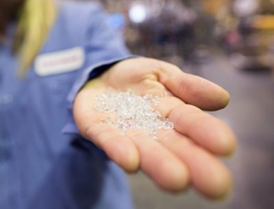 Pellets from plastic waste recycling in a person’s hand. 