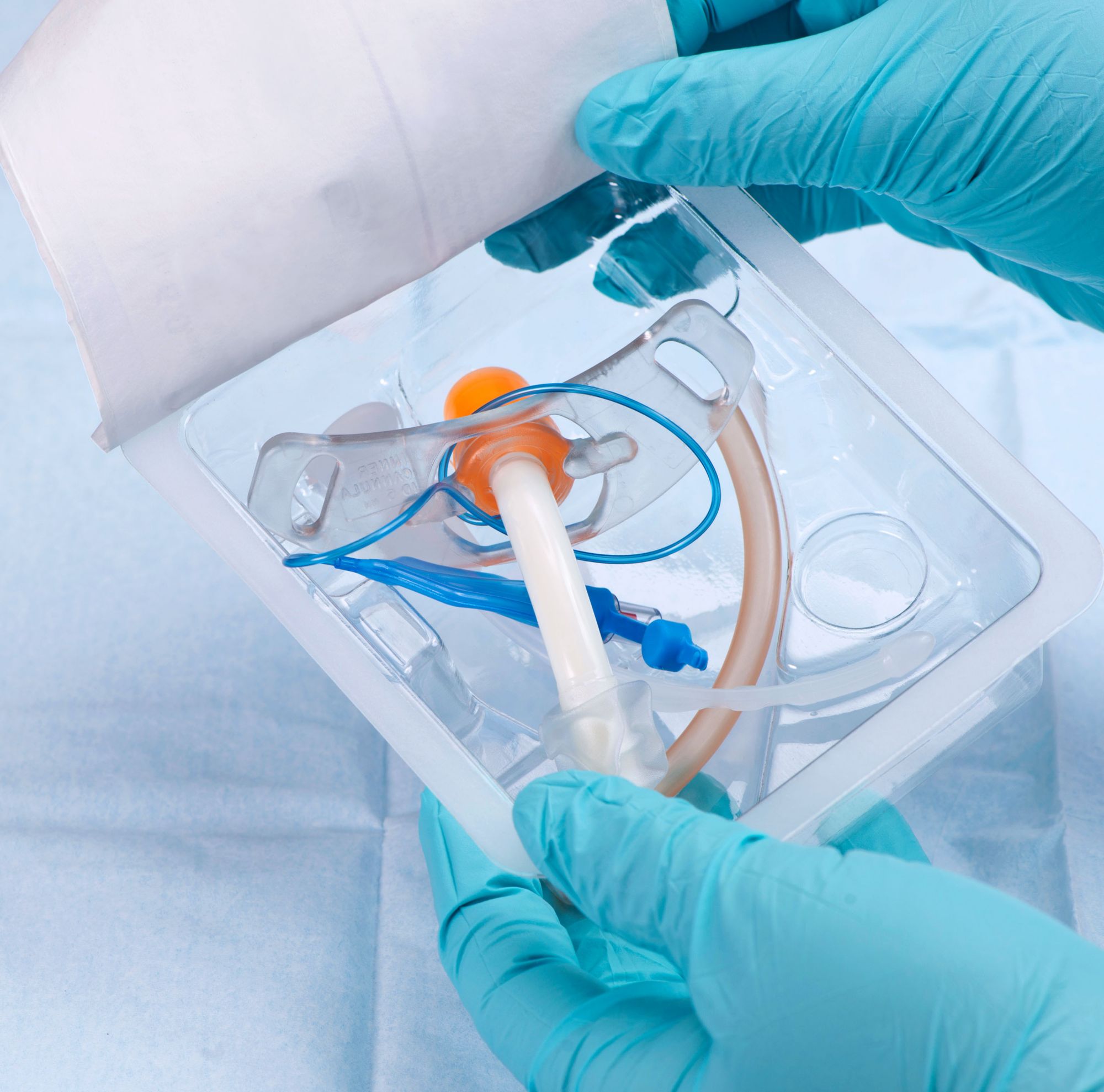 Gloved hands opening sterile medical packaging. 