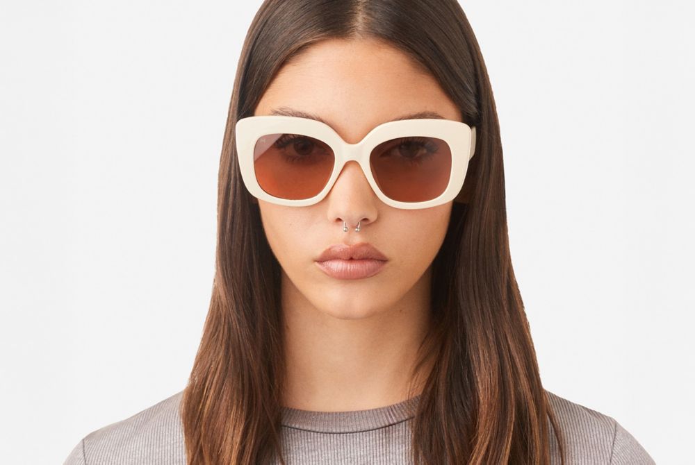 A person wears white Hawkers sunglasses. 