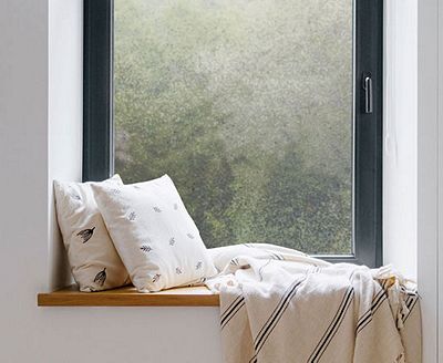 Cozy, private window nook showing the installed Ice Chips film behind throw pillows.