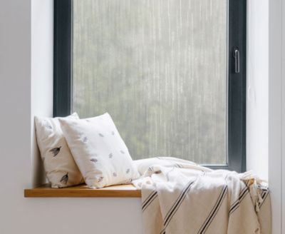 Cozy, private window nook showing the installed Ice Forest film behind throw pillows.