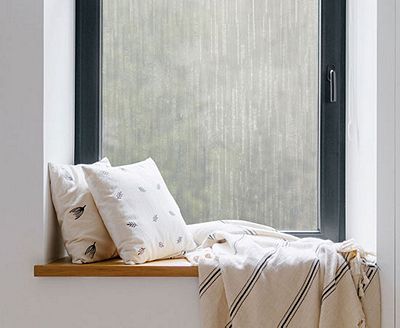 Cozy, private window nook showing the installed Ice Forest film behind throw pillows.