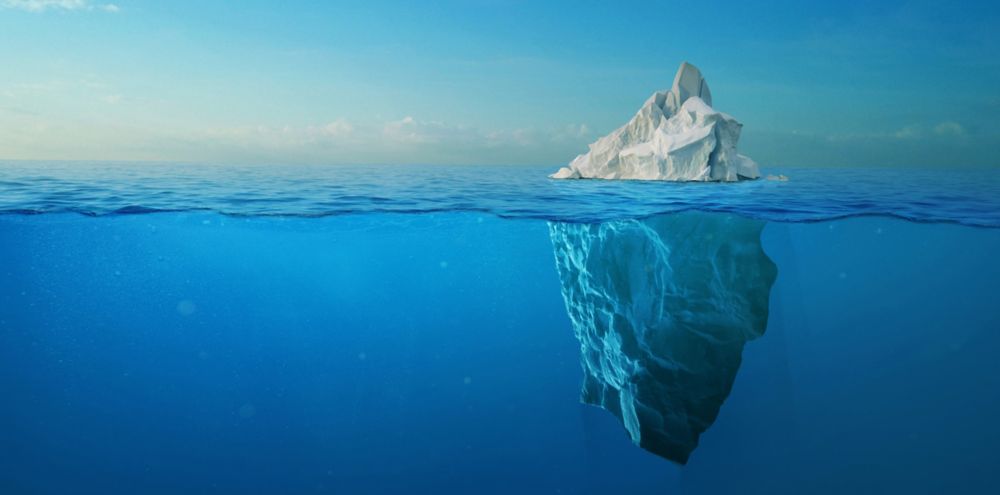 An iceberg seen from above and below the ocean surface 