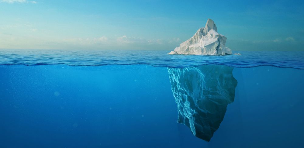 An iceberg seen from above and below the ocean surface 