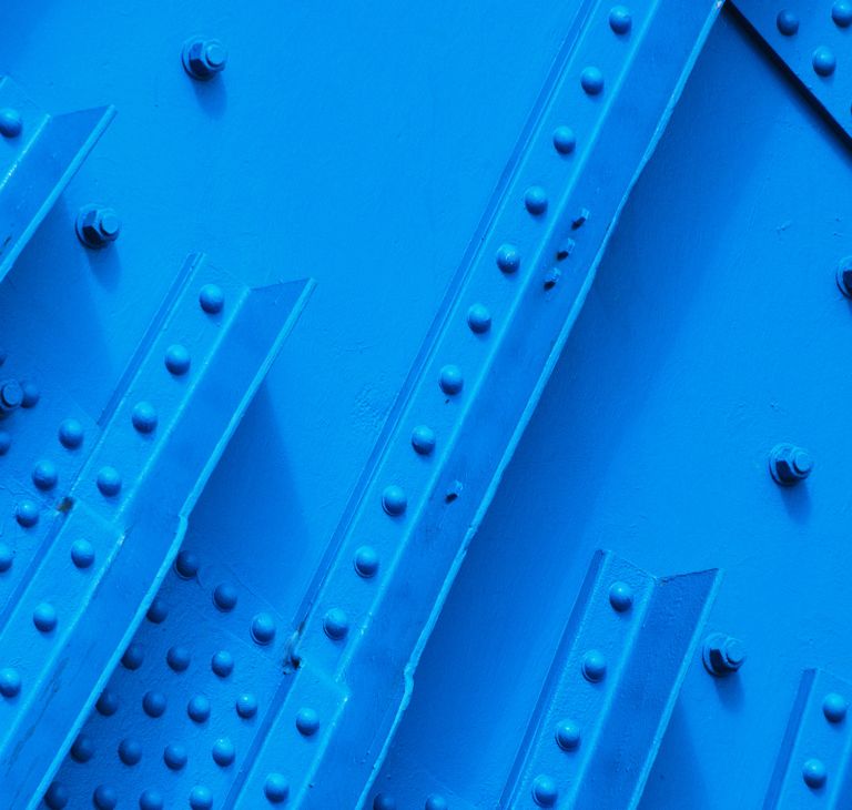 Close-up of industrial metal of a blue bridge. 
