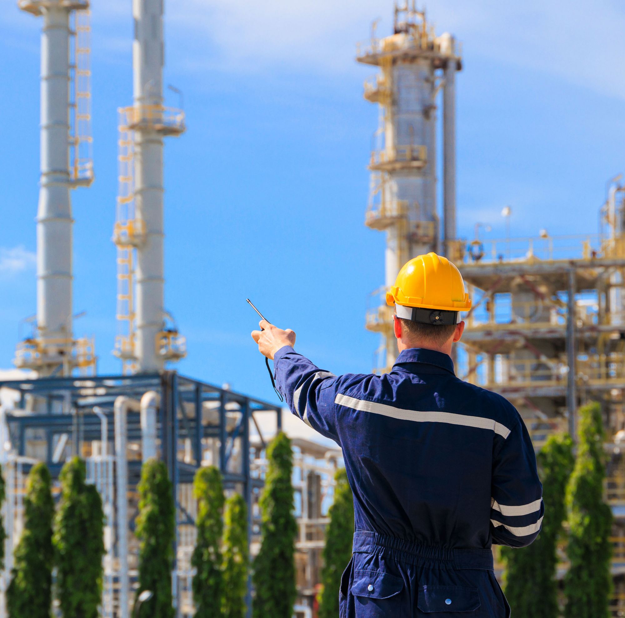 An industrial engineer wearing PPE in a petrochemical plant.   