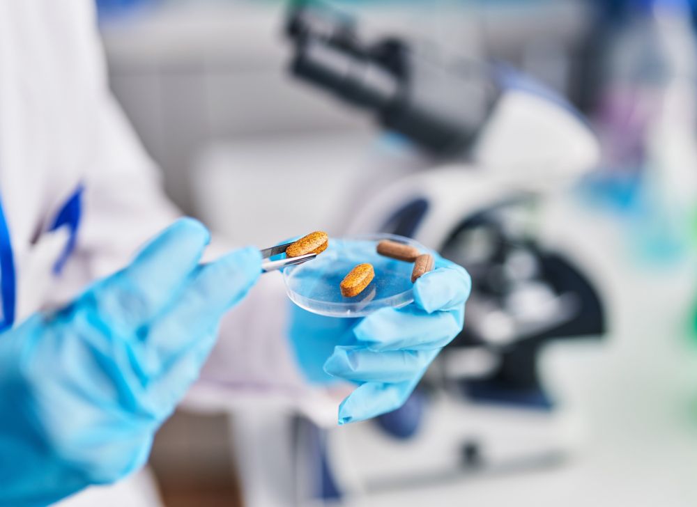 A researcher inspecting pills in the lab. 
