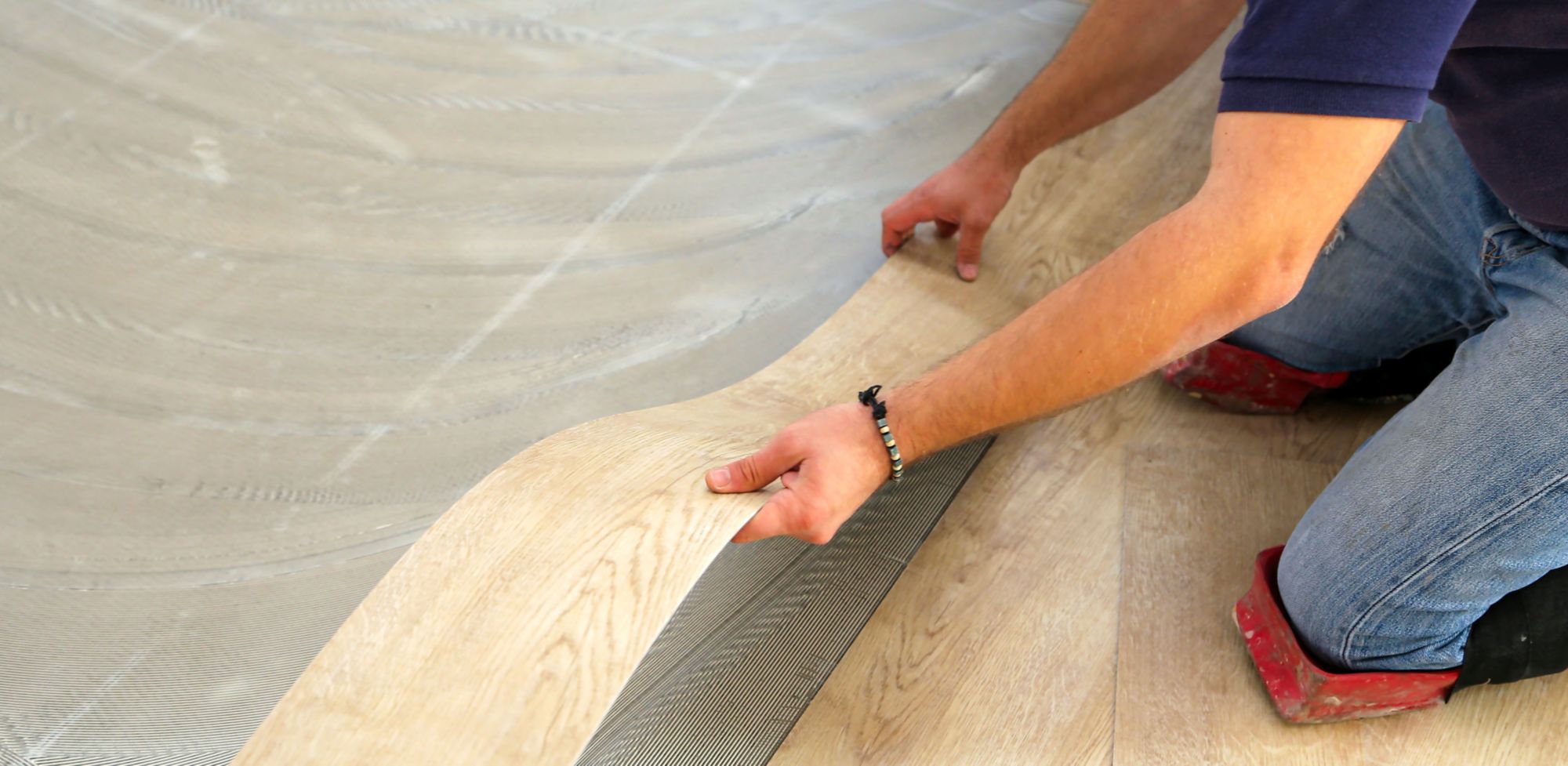 A person installs vinyl flooring. 