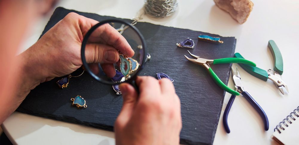 A jeweler looks at an item under a magnifying glass 