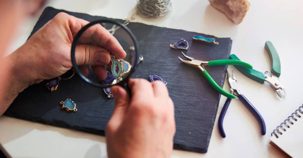 A jeweler looks at an item under a magnifying glass 