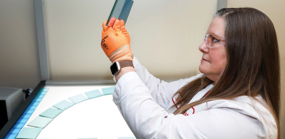 Julia looks at two glass samples in the lab