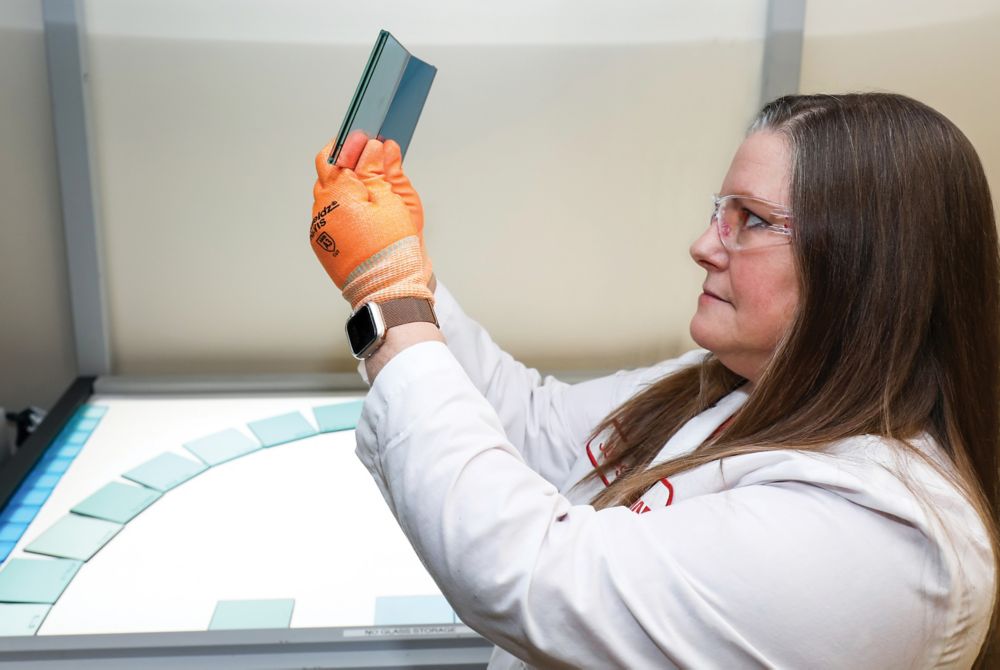 Julia looks at two glass samples in the lab 