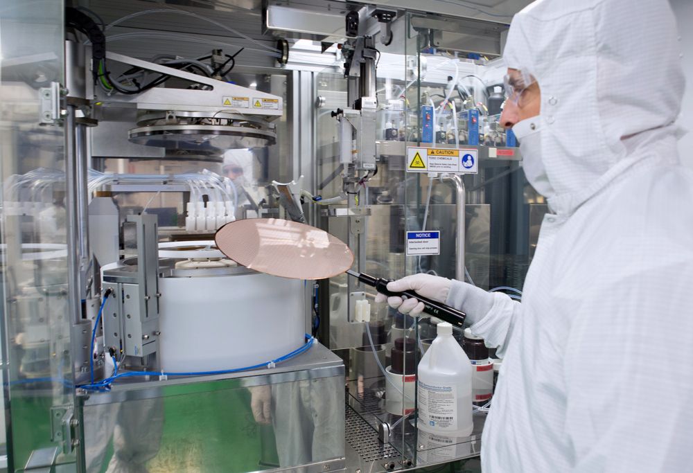 Lab technician examines liquid through a magnifying glass 