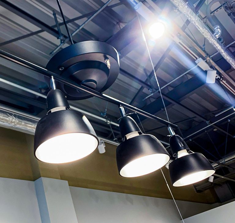 Large bright lamps hang in an industrial building. 