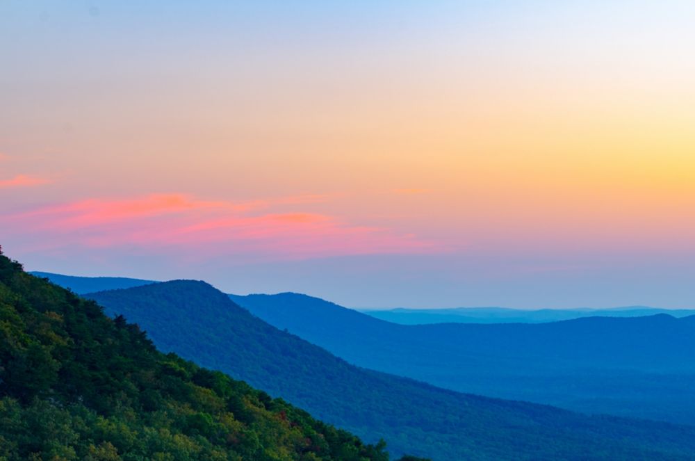 Landscape view of tree-covered mountains at sunrise. 