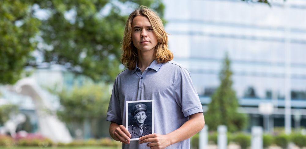 Mark Sago holding a black and white photo of his great-grandfather 