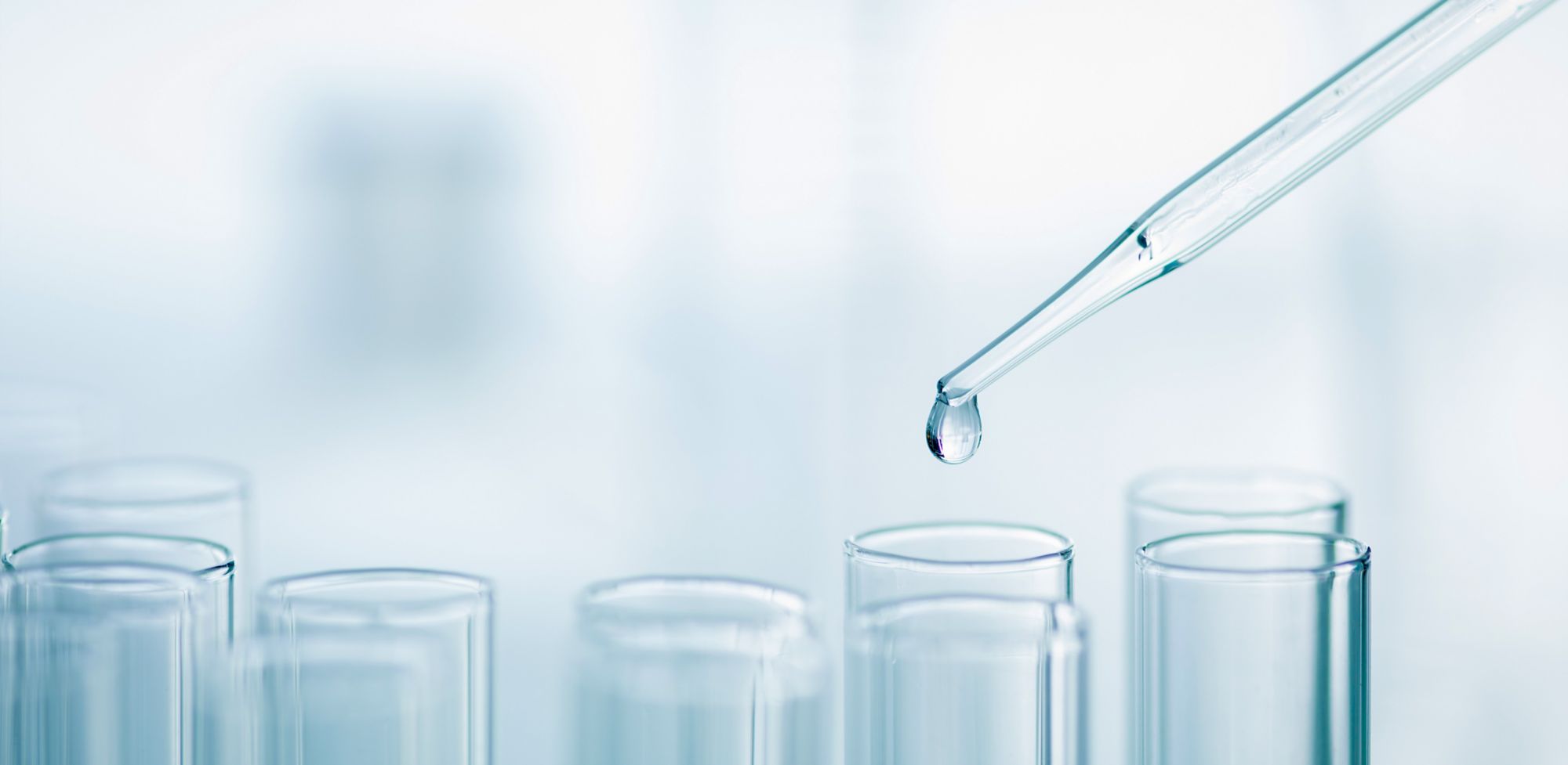 Clear liquid drips from pipette into a test tube. 