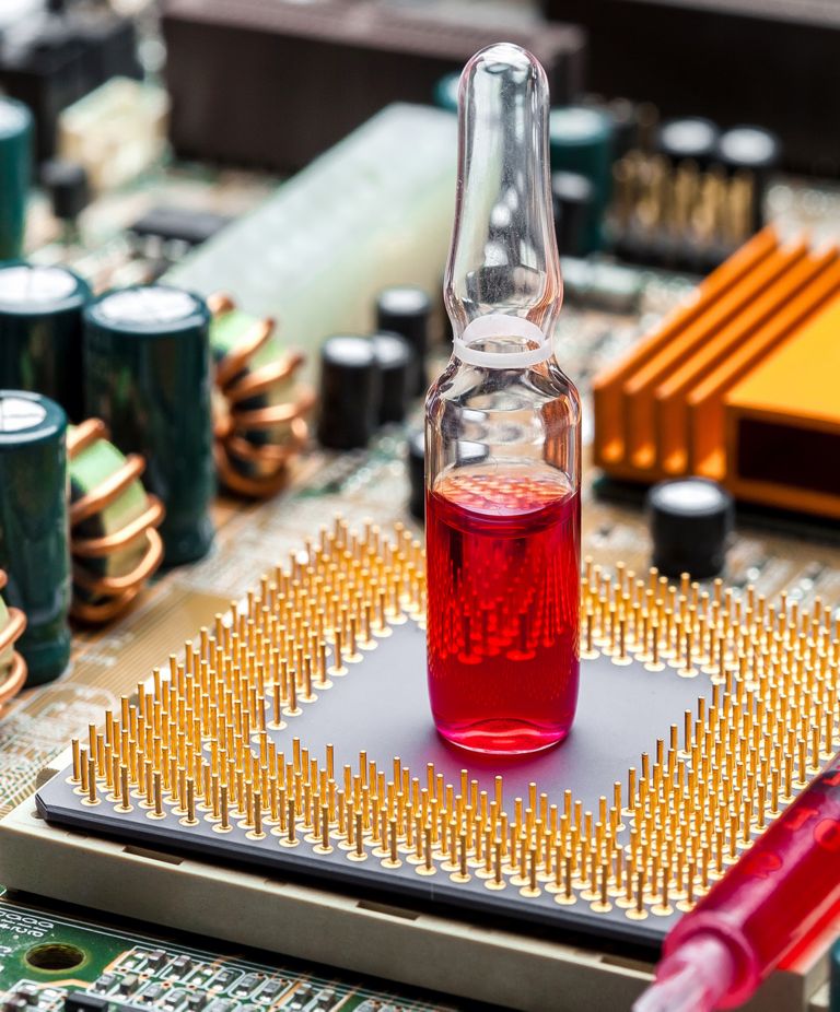 Red liquid in a vial sits on an electronic board 