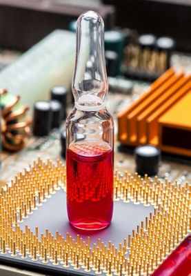 A vial of red liquid sits on an internal electronic component.