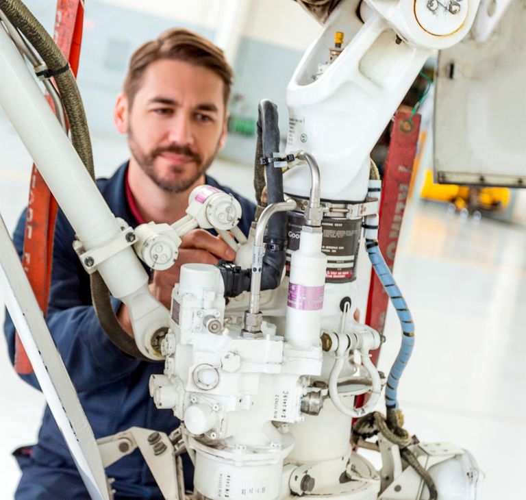 A man looks over mechanical components. 