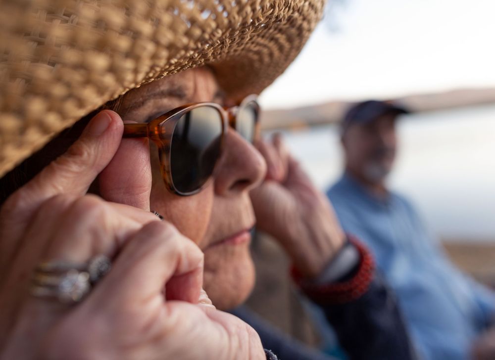 Woman adjusting her Tritan sunglasses as she enjoys the outdoors. 