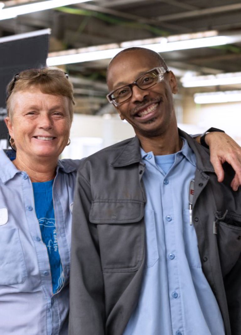 Two Eastman team members stand in front of a veteran’s resource group display. 
