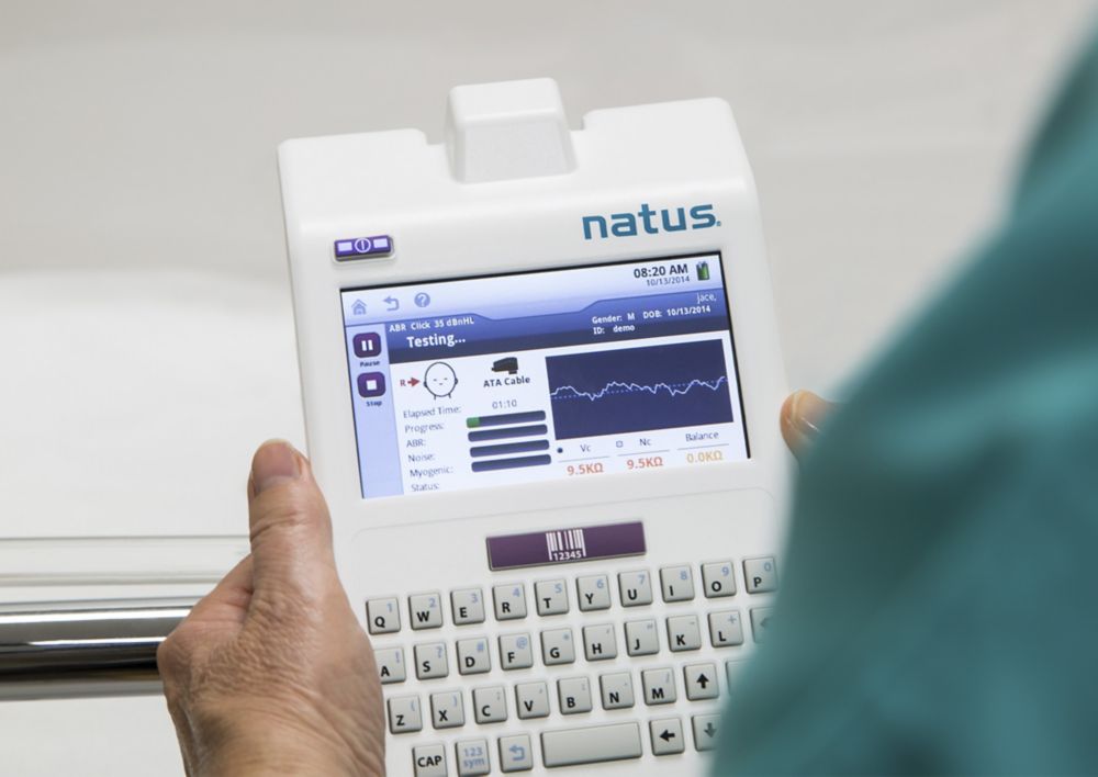 Healthcare provider holding hearing screening equipment.   