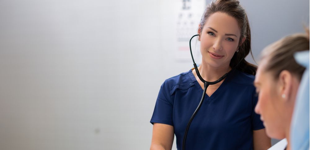 A medical professional uses a stethoscope on a patient.