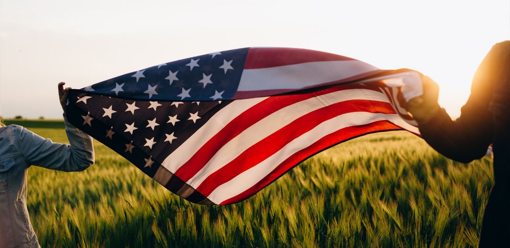 American flag held over a wheat field  