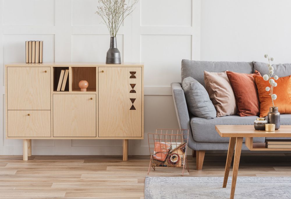 A couch, a wooden display case and a wooden coffee table in a living room. 