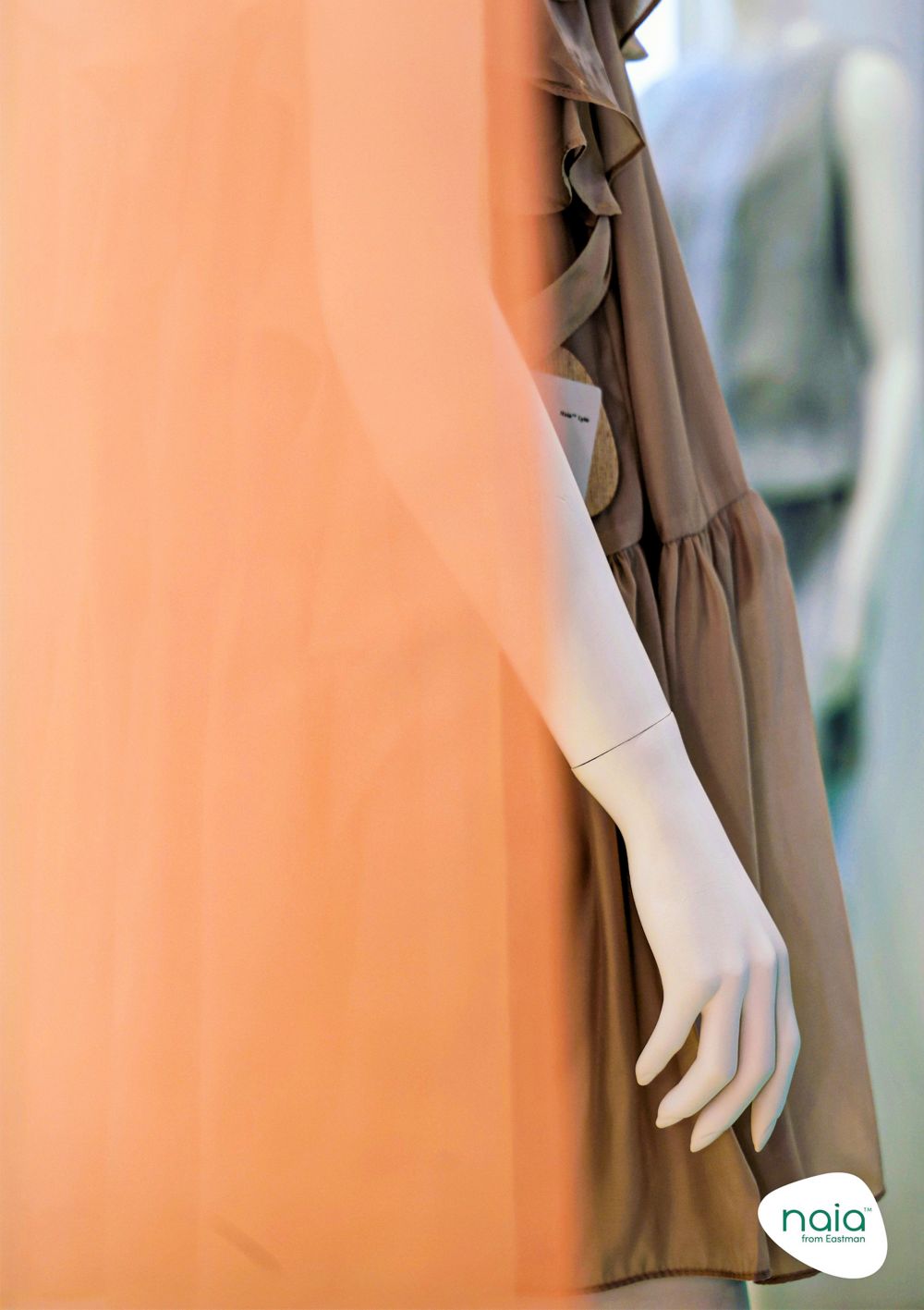 A mannequin wears a brown, lightweight dress made with Naia Lyte. 