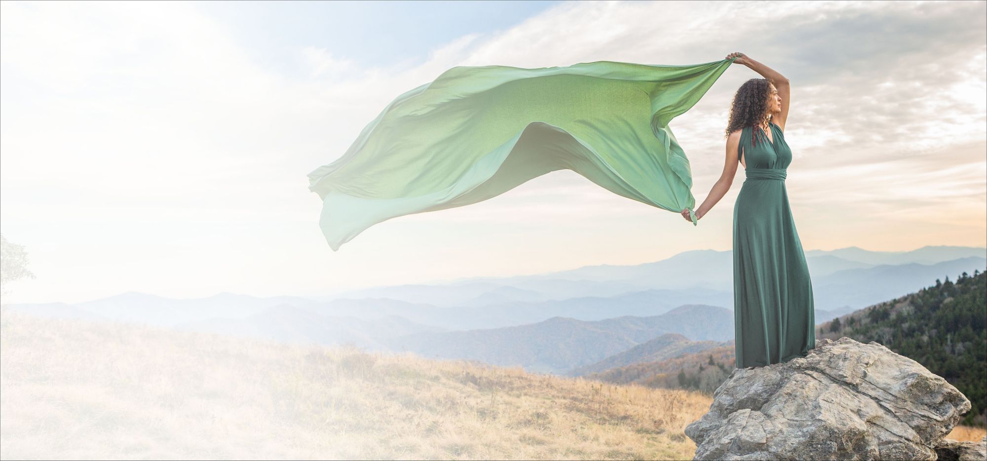 Green fabric draped in sunlight creates shadows in the folds of the material. 