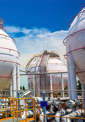 Large white spherical propane tanks storing fuel outdoors.