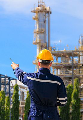 An industrial engineer wearing PPE in a petrochemical plant.  