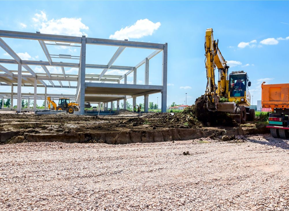 An excavator removes dirt from a surface. 