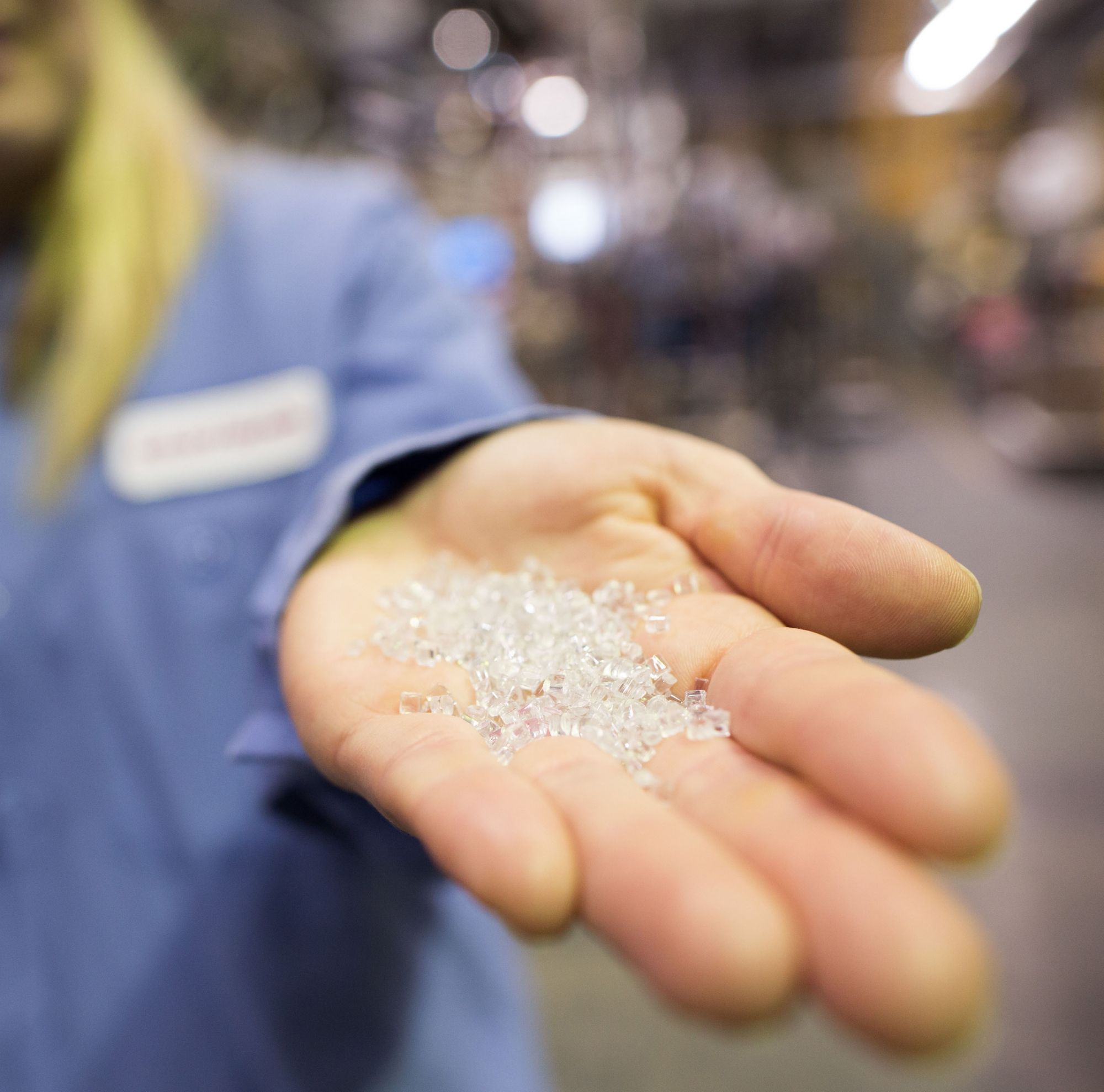 A person holds pellet granules in their outstretched hand. 
