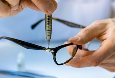 A person tightening a screw on eyeglasses. 