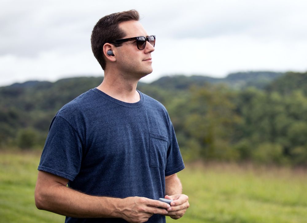 Person listening to music outside on wireless earbuds. 