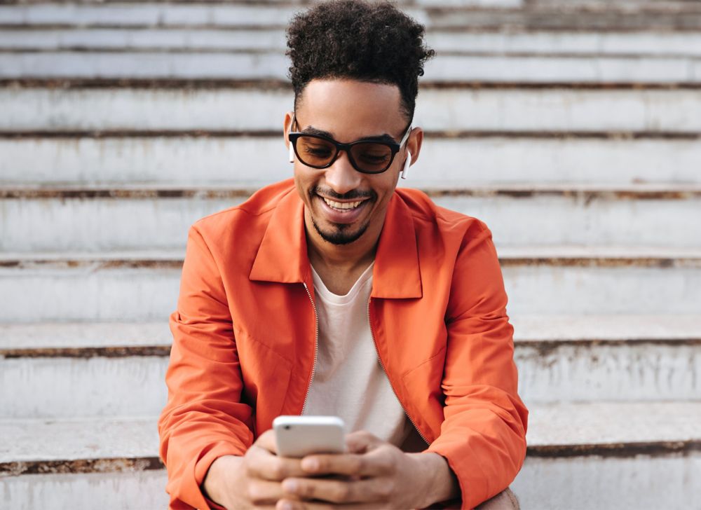 A person uses a phone while wearing sunglasses. 