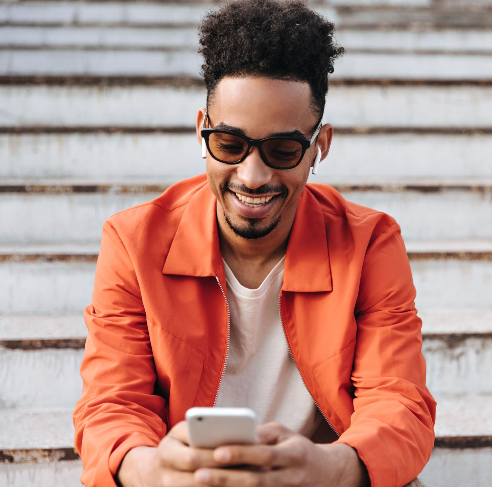 A person uses a phone while wearing sunglasses. 